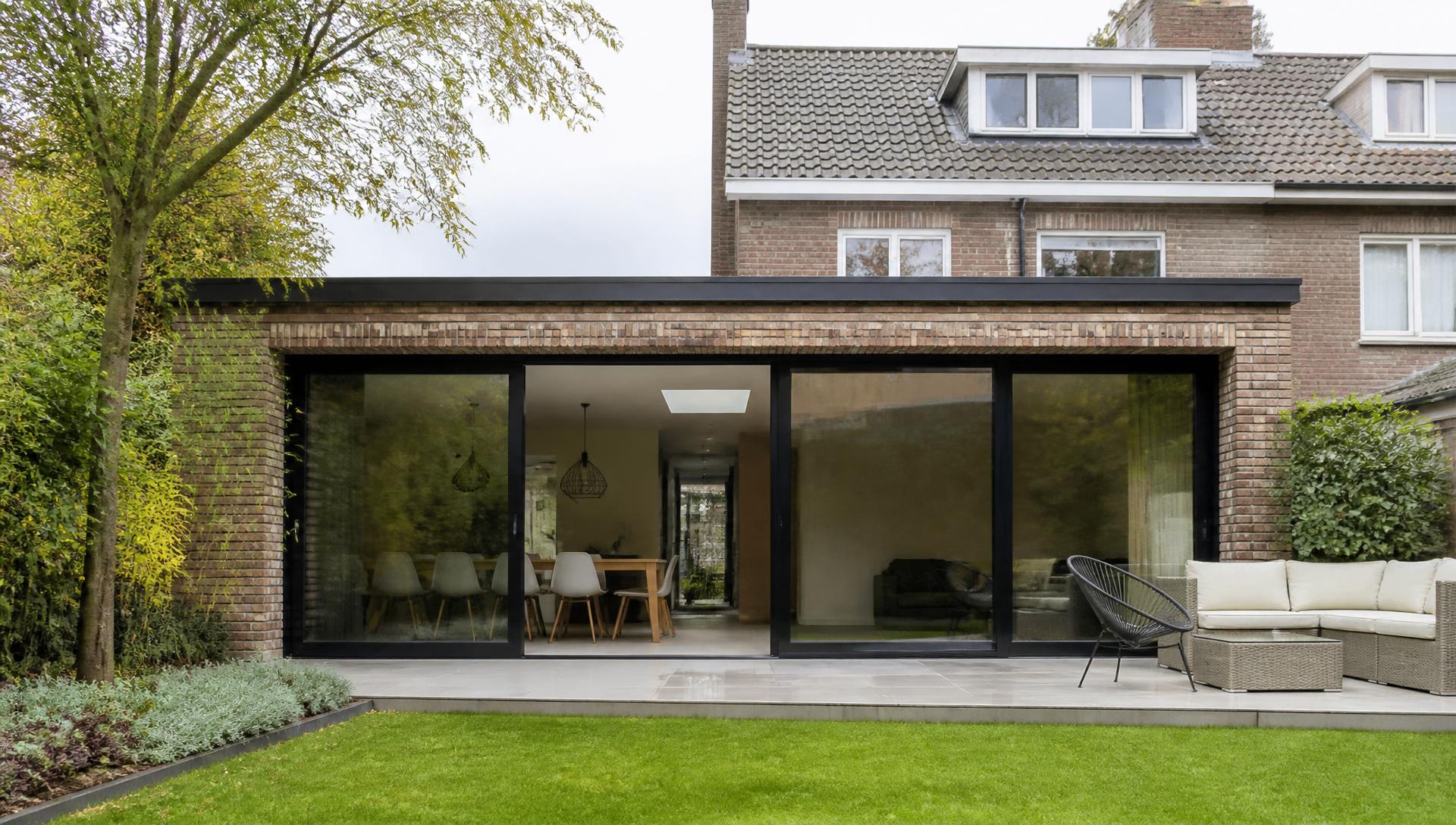 Moderne aanbouw met grote schuifpui, gerealiseerd door AanbouwXpert